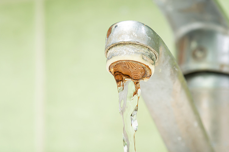 faucet-scale-buildup water flowing from faucet with scale buildup