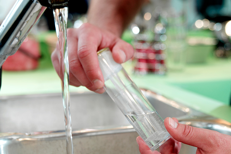 water-testing-sample test tube being filled with tap water for testing.